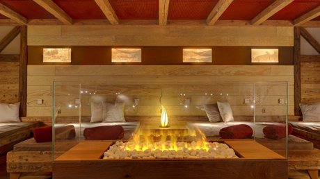 Entspannung im Bayerischen Wald: im Wellnesshotel Hofbräuhaus Ruheraum mit gemütlichen Liegen, Kaminfeuer und stimmungsvoller Beleuchtung im Wellnesshotel Hofbräuhaus Bodenmais