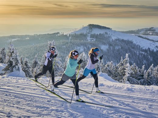 Langlaufen und Winterwandern: Bodenmais im Winter Drei Frauen beim Langlaufen am Bretterschachten in Bodenmais mit traumhafter Bergkulisse im Hintergrund - Wintersport nahe dem Welnesshotel Hofbräuhaus im Bayerischen Wald