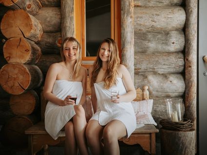 Herrliche Tageswellness in Bodenmais Zwei Frauen entspannen nach der Sauna auf einer Holzbank im FKK-Bereich des Wellnesshotels Hofbräuhaus, Bodenmais, Bayerischer Wald