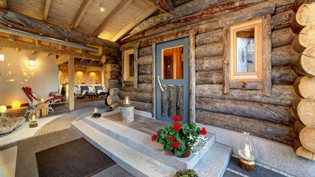 Sauna mit FKK: Urlaub im Bayerischen Wald Blockhaus aus Keloholz mit Blumen, Kerzen und Ruheliegen im Wellnesshotel Hofbräuhaus Bodenmais