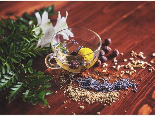 Wellnessurlaub und Tageswellness in Niederbayern Tee mit Kräutern und Blüten auf Holz