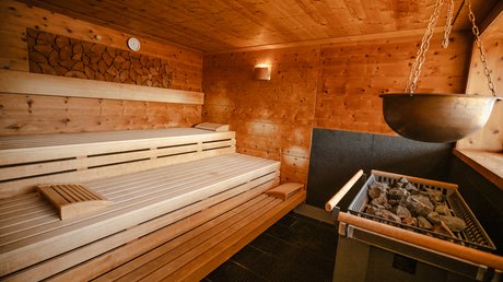 Hofbräuhaus Wellnesshotel: textilfrei saunieren Zirbensauna mit Holzverkleidung, Aufgusskessel und Saunabänken im Wellnesshotel Hofbräuhaus Bodenmais
