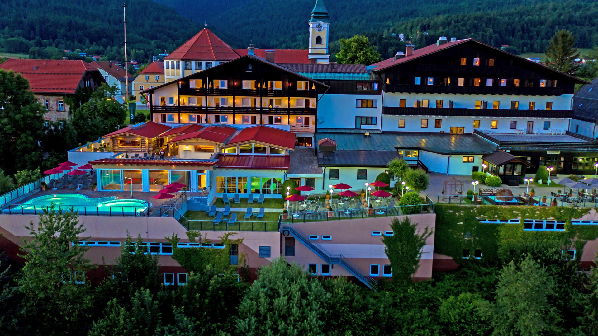 Wellnesshotel im Bayerischen Wald: Außenansicht des Wellnesshotel Hofbräuhaus in Bodenmais mit Außenpool, Saunen und Bergpanorama