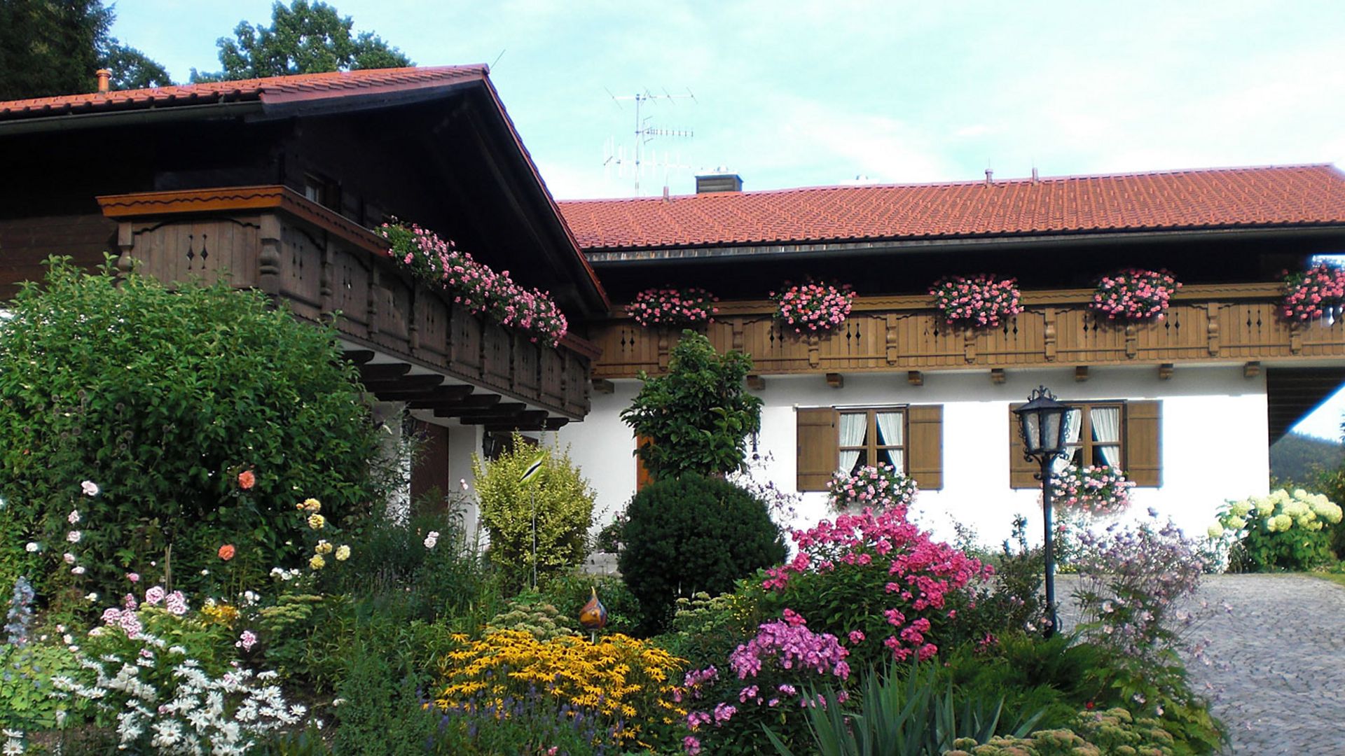 Urlaub und wandern rund um Bodenmais: Ferienhaus Freiblick Rustikales Holzhaus mit üppigen Blumen - Ferienhaus vom Hotel Hofbräuhaus in Bodenmais.