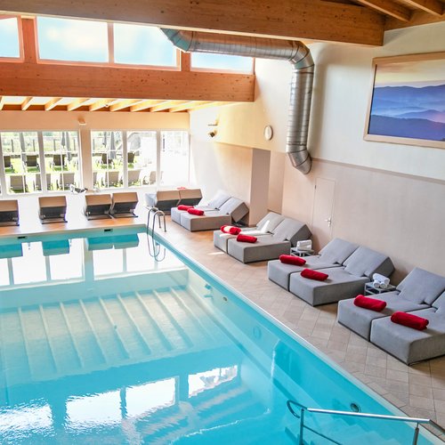 Häufige Fragen zum Wellnesshotel Hofbräuhaus in Bodenmais Großes Hallenbad mit Tageslicht und Relaxliegen im Wellnesshotel Hofbräuhaus Bodenmais – moderner Poolbereich für Gäste