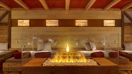 Entspannung im Bayerischen Wald: im Wellnesshotel Hofbräuhaus Ruheraum mit gemütlichen Liegen, Kaminfeuer und stimmungsvoller Beleuchtung im Wellnesshotel Hofbräuhaus Bodenmais