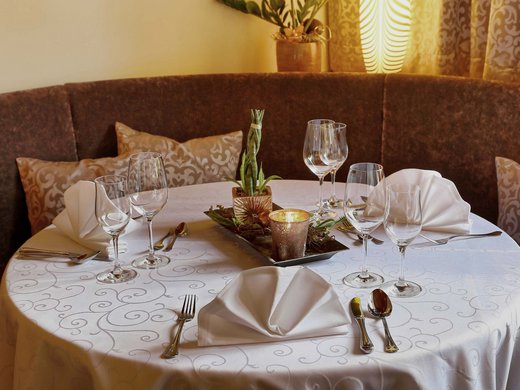 Hofbräuhaus: Restaurant in Bodenmais Gemütlicher runder Tisch mit stilvoller Dekoration und gemütlicher Sitzecke im Restaurant des Wellnesshotels Hofbräuhaus Bodenmais