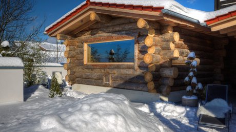 Sauna mit FKK: Urlaub im Bayerischen Wald Kelosauna aus echtem Keloholz im Winter mit Schnee und Panoramafenster im Wellnesshotel Hofbräuhaus Bodenmais