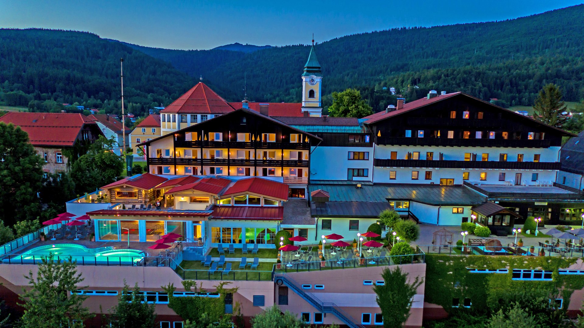 Wellnesshotel im Bayerischen Wald: Außenansicht des Wellnesshotel Hofbräuhaus in Bodenmais mit Außenpool, Saunen und Bergpanorama