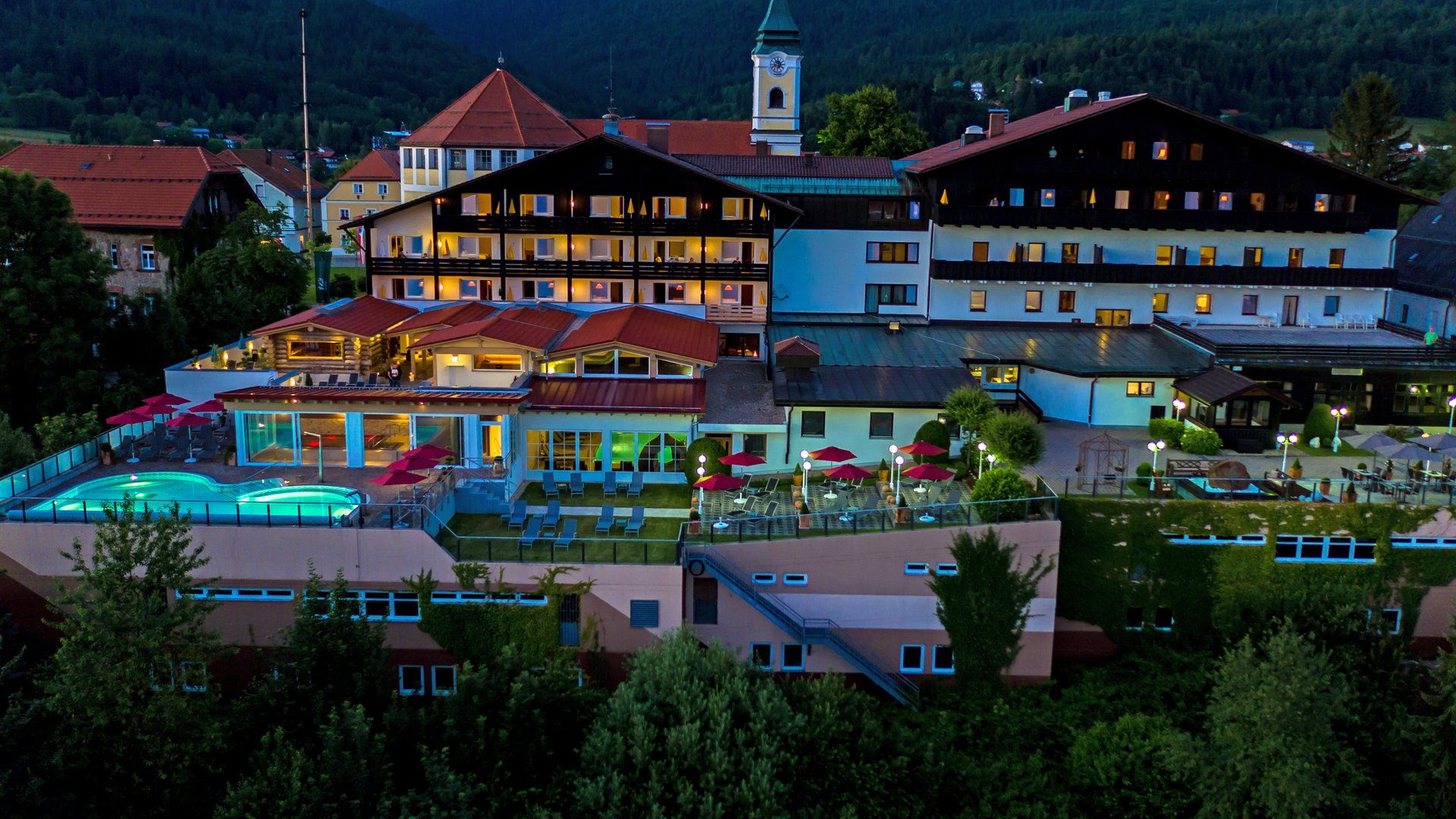 Wellnesshotel im Bayerischen Wald: Außenansicht des Wellnesshotel Hofbräuhaus in Bodenmais mit Außenpool, Saunen und Bergpanorama